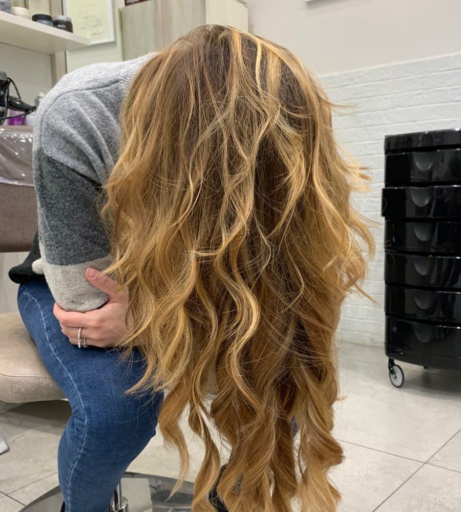 Onde miele lunghe: la cliente piegata in avanti, il viso nascosto dai capelli.