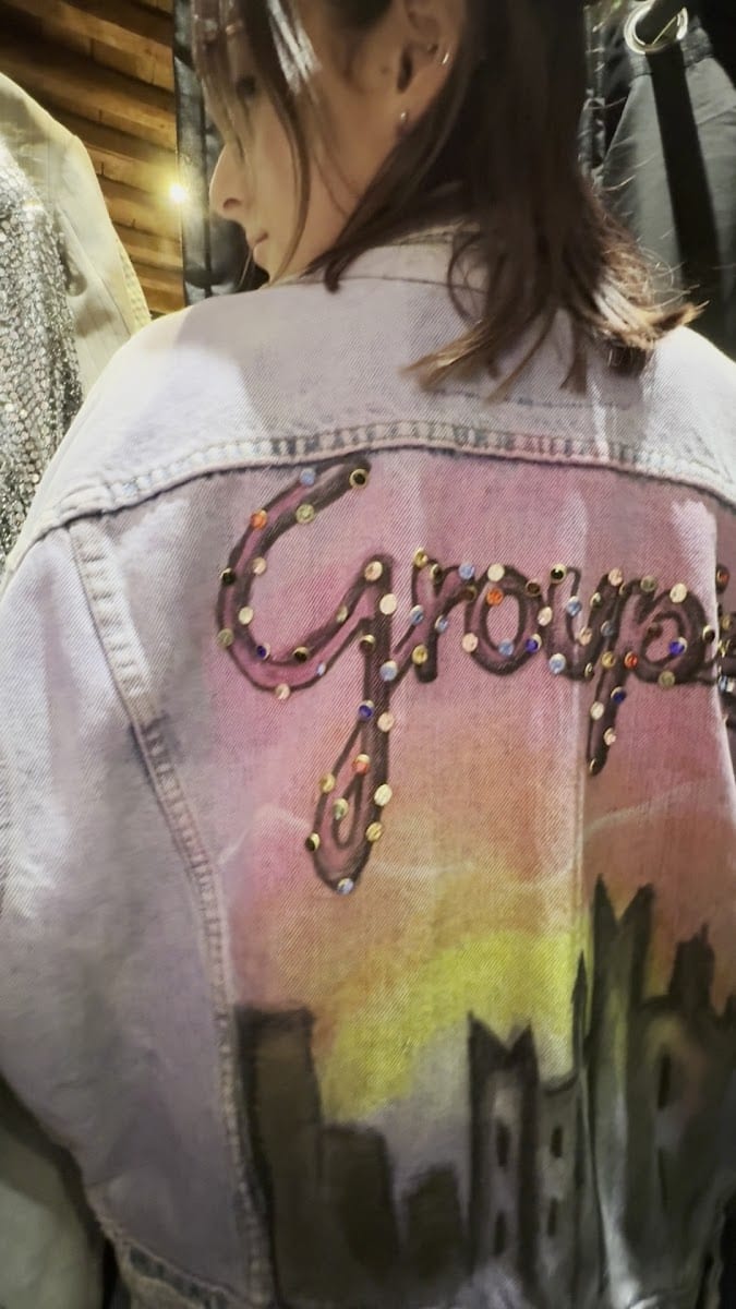 Una giacca di jeans customizzata a mano con la scritta Groupies