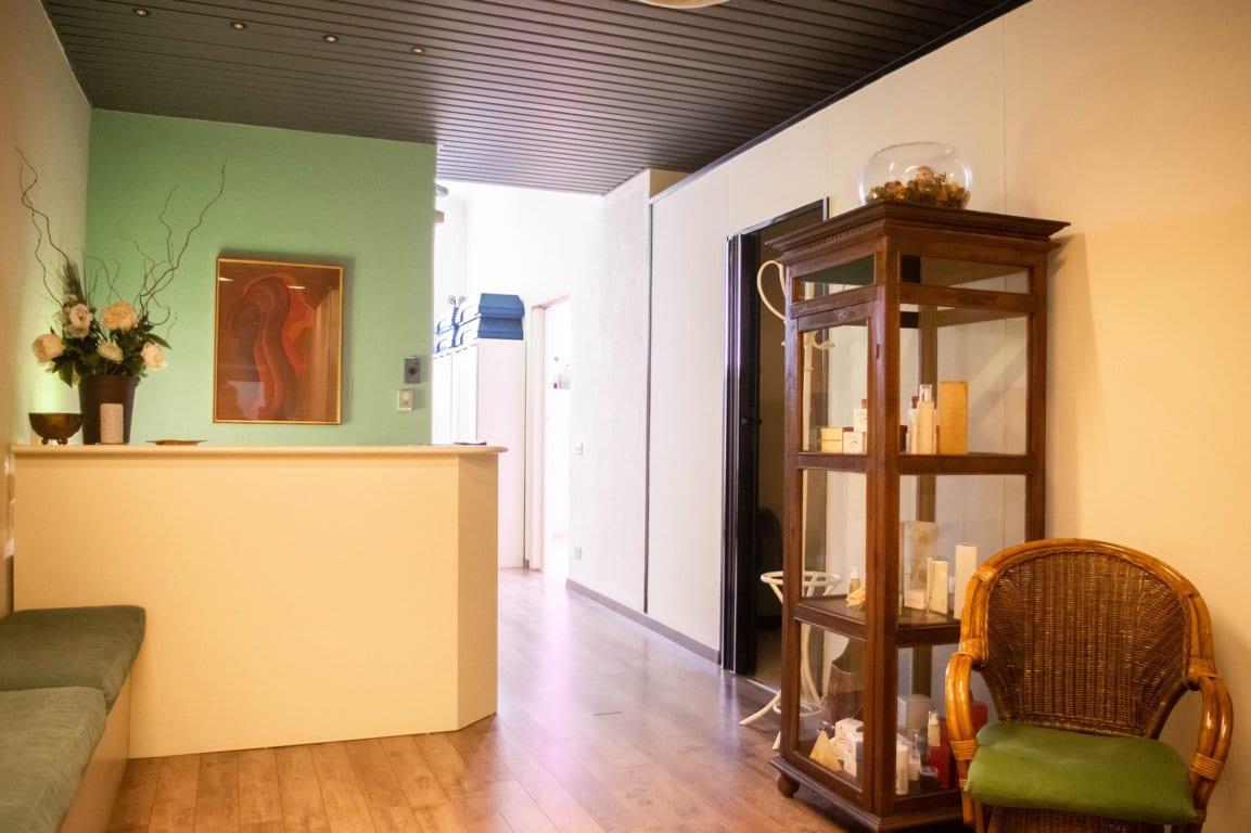 La reception de Il Giglio Benessere, un'oasi di relax con la parete verde salvia