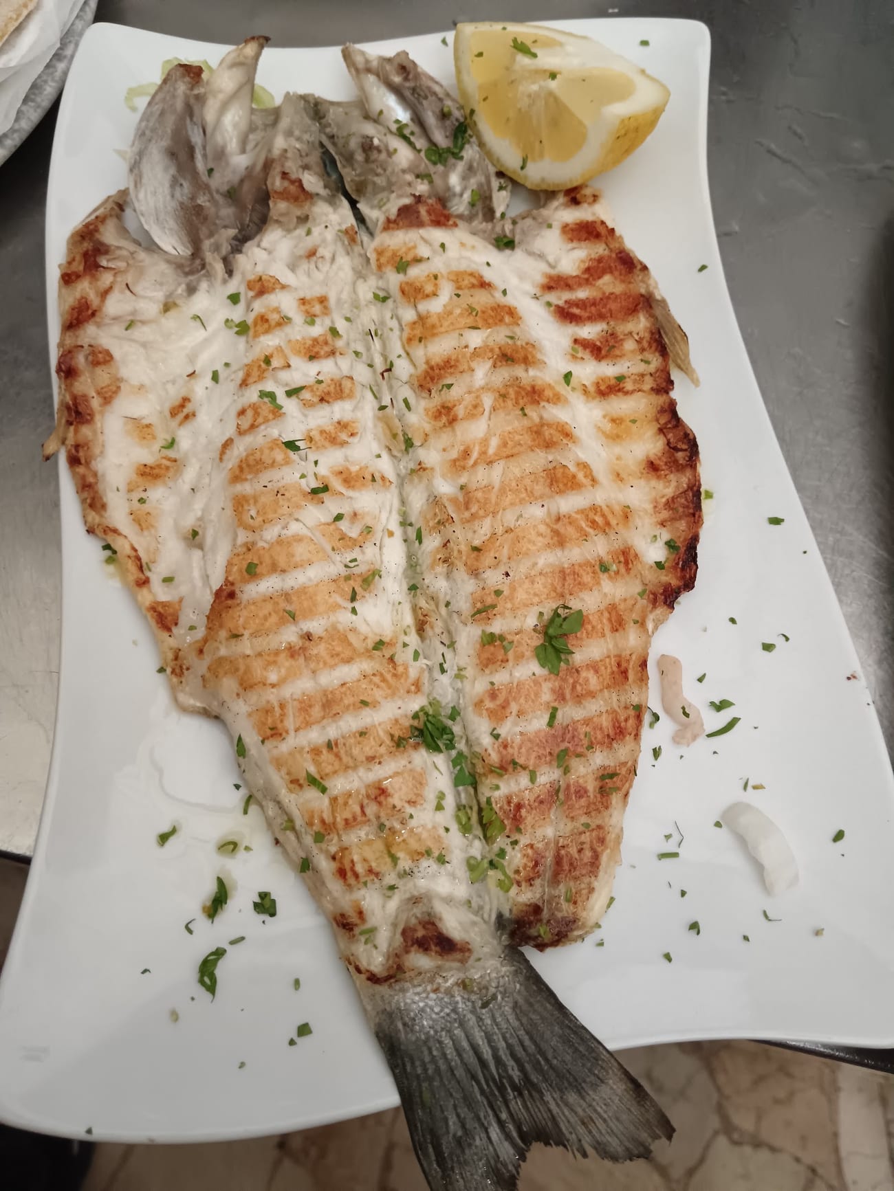 Branzino alla griglia aperto a libro con spicchio di limone