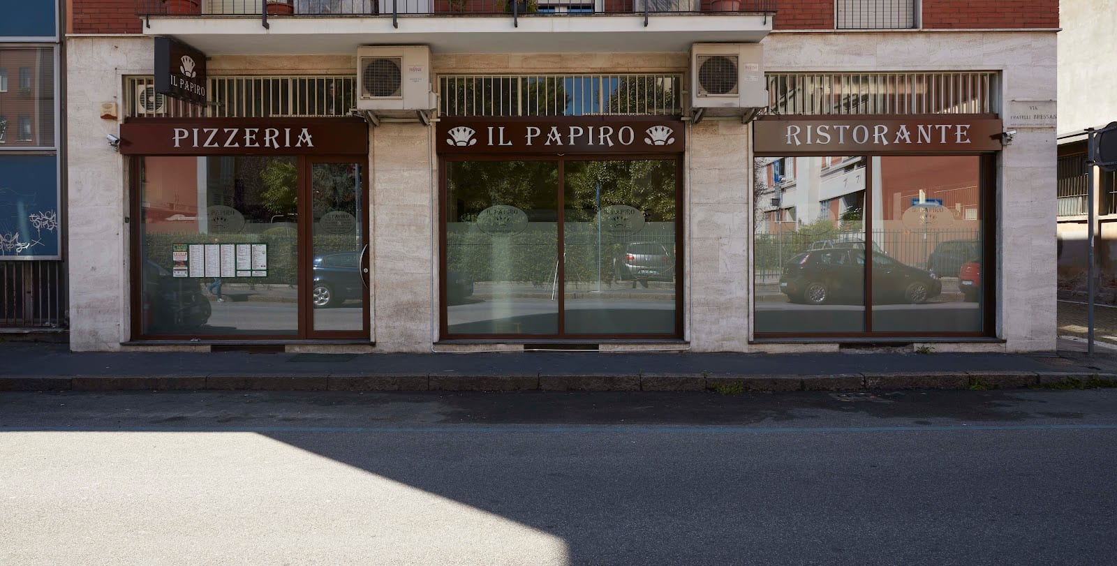 La facciata del Papiro in via Fratelli Bressan: tre vetrine con le insegne pizzeria, Il Papiro e ristorante