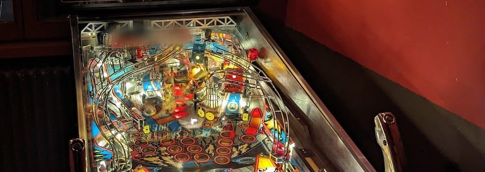 Le rampe cromate e le luci del flipper, accanto alla parete rossa