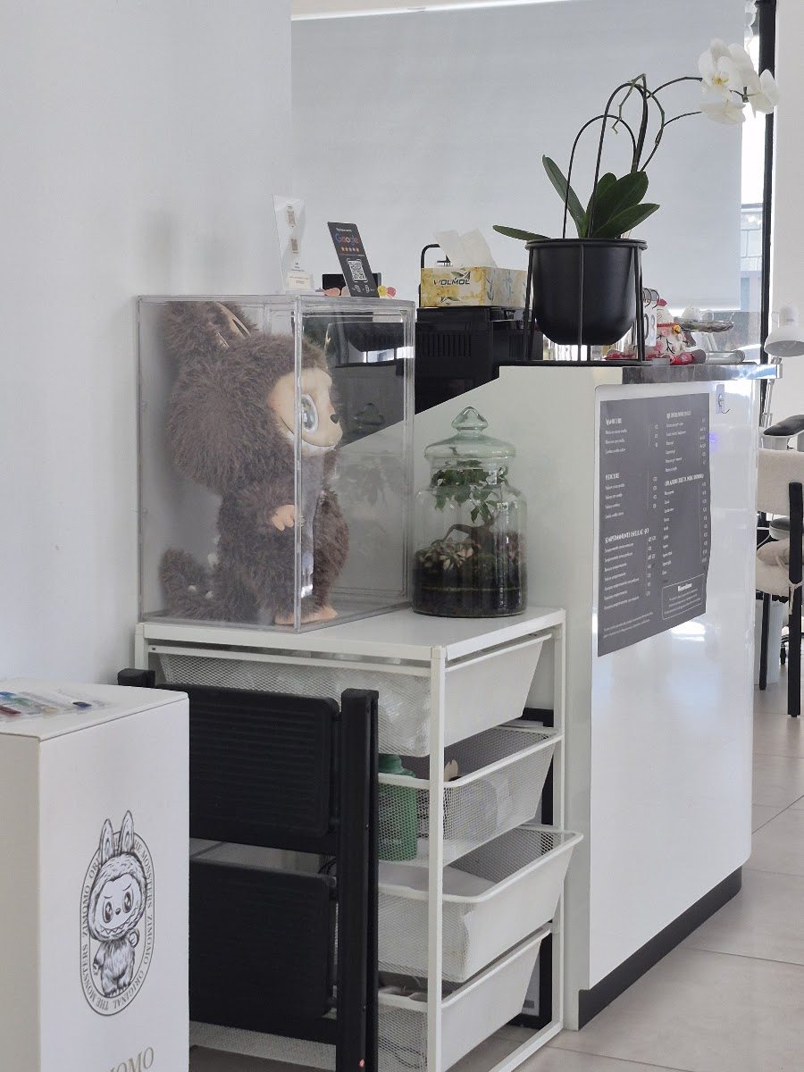 Il bancone della reception con orchidea e listino dei servizi