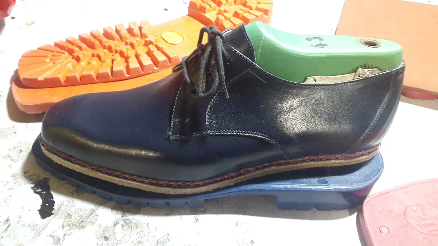 Una scarpa risuolata con suola colorata e cuciture a contrasto