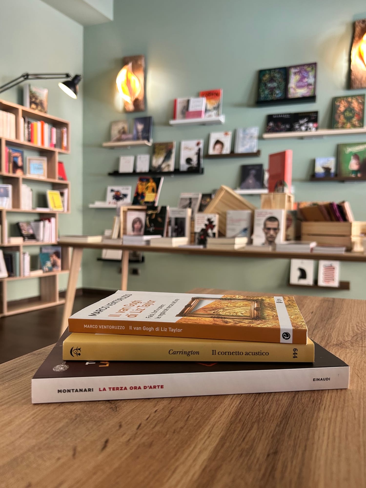 Una pila di libri d'arte scelti, sul tavolo di legno della libreria
