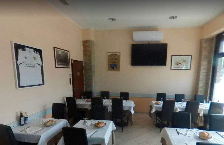 La sala de La Conchiglia con le tovaglie bianche e la maglia da calcio firmata