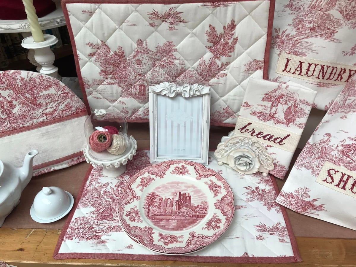 La toile de Jouy rossa: sacche ricamate, un piatto e una teiera.