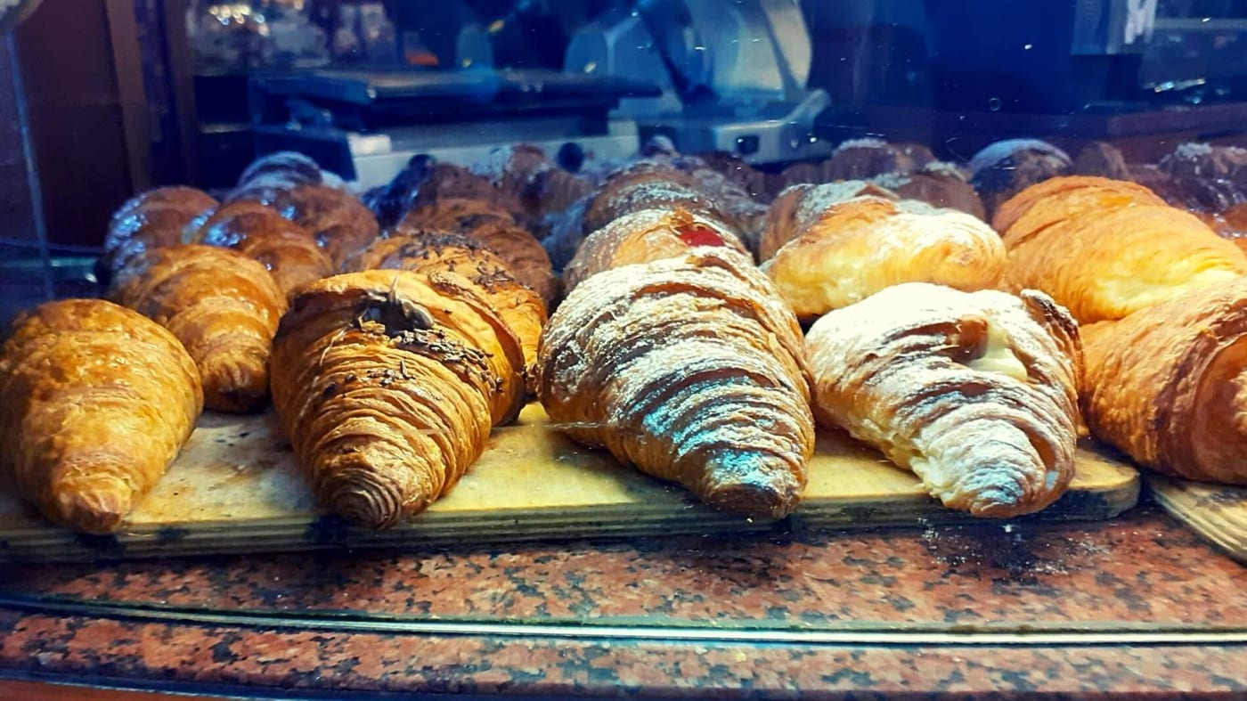 Le brioche nella vetrina, sul granito rosso: al cioccolato, allo zucchero a velo, vuote