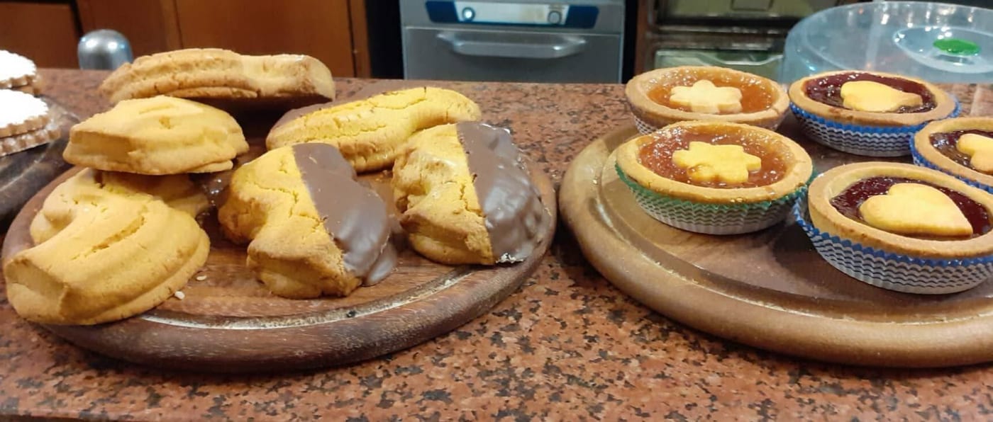 Biscotti di frolla, alcuni col cioccolato, e crostatine alla marmellata sul granito