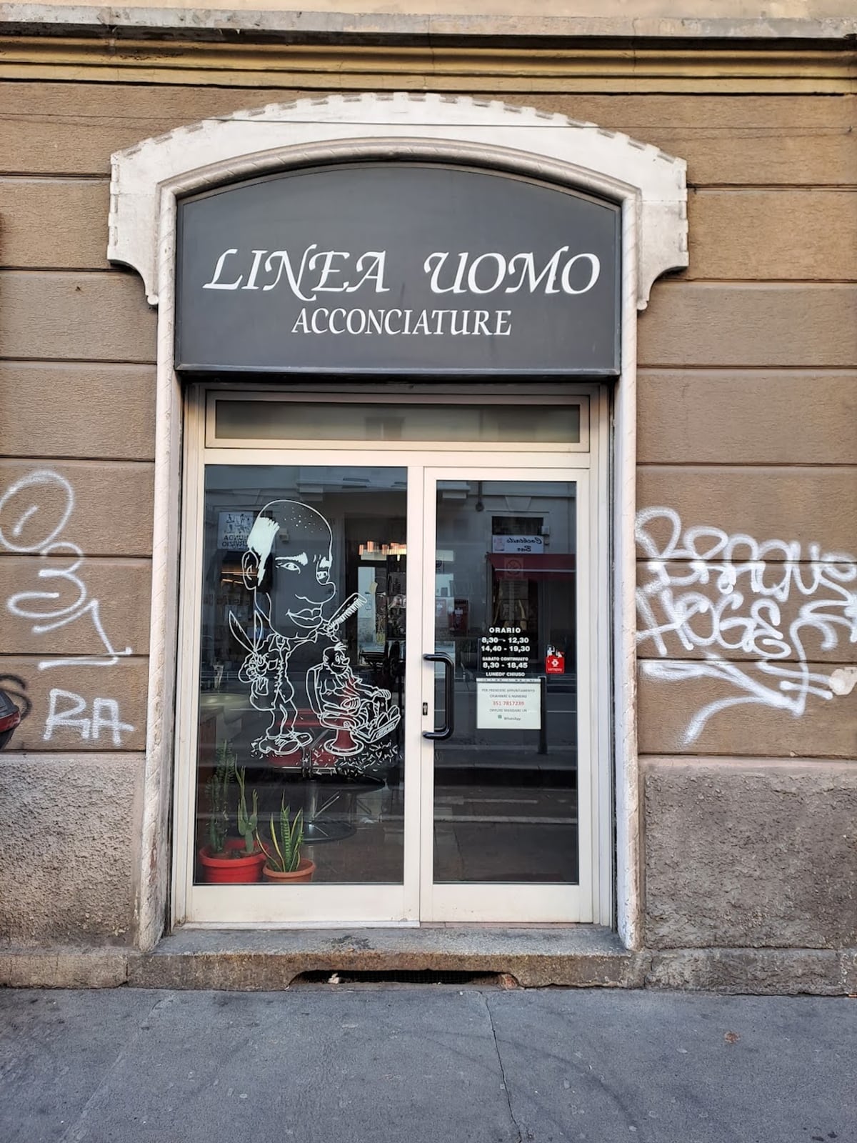 La vetrina di Linea Uomo in Via Imbonati, con l'insegna e il disegno sul vetro