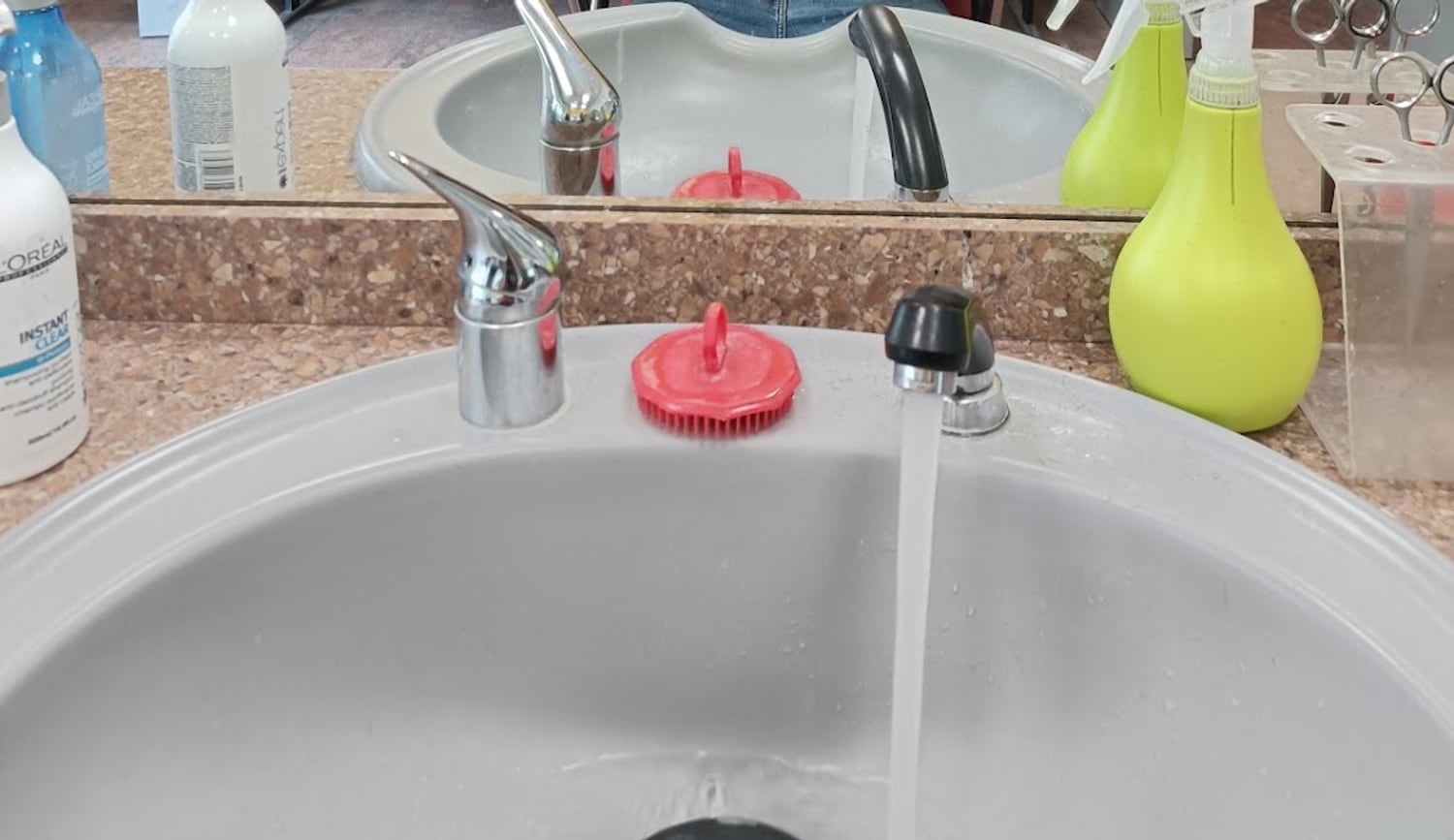 Il lavatesta con i prodotti e le forbici sul ripiano