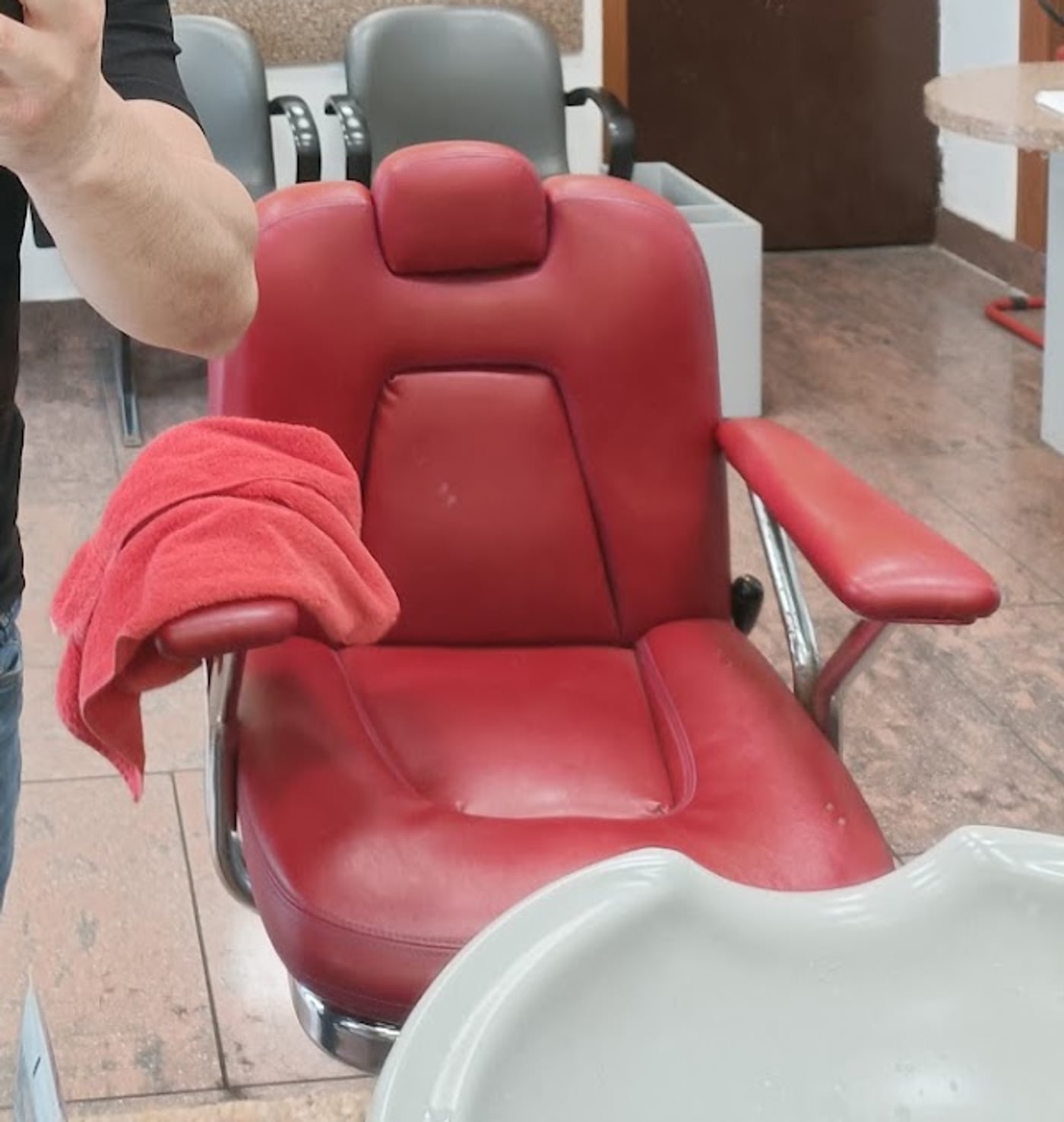 La poltrona rossa del salone, con il telo pronto