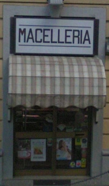 La vetrina della macelleria con la tenda a righe e l'insegna Macelleria