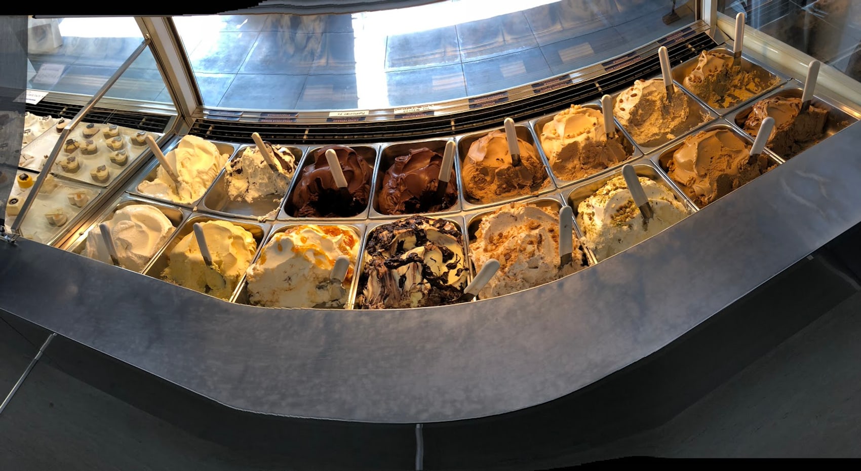 Il banco curvo in acciaio inox con le vaschette del gelato
