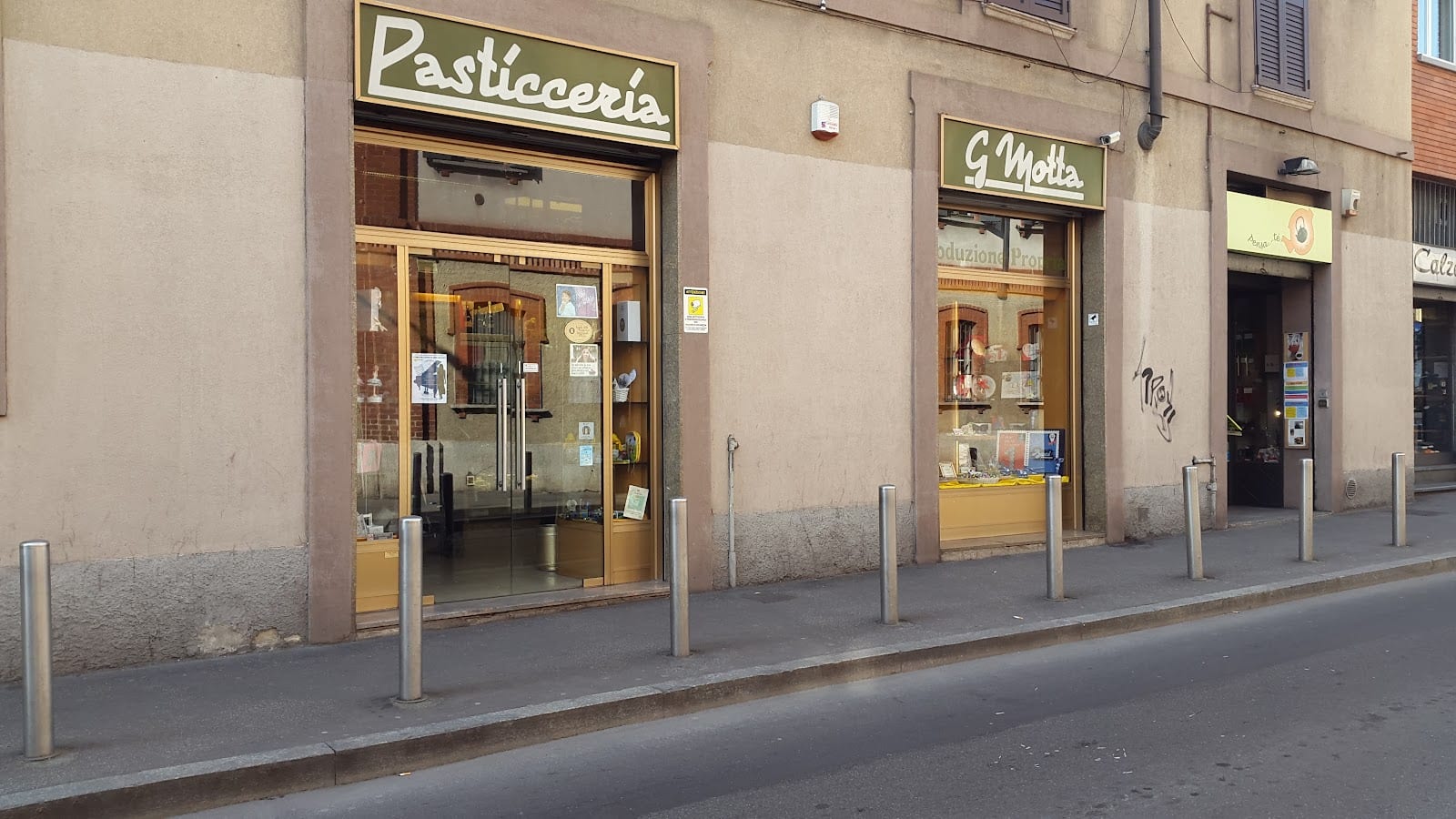 Le due insegne verdi e oro di via Cislaghi: Pasticceria su una vetrina, G. Motta sull'altra