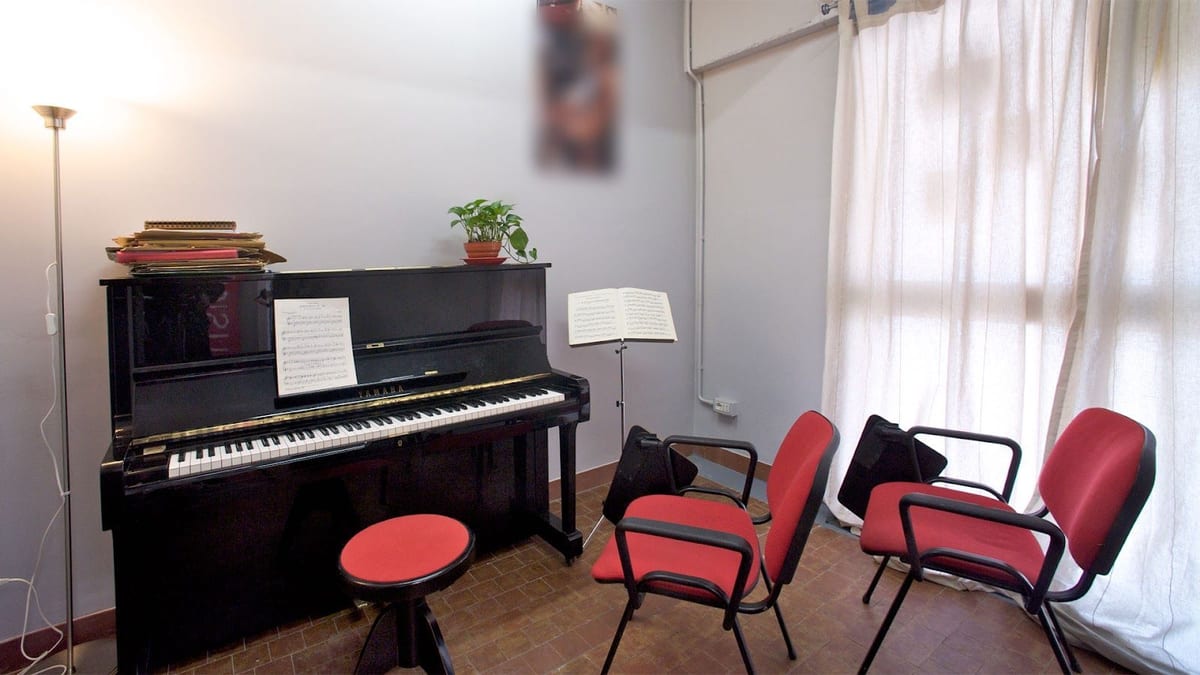 L'aula del pianoforte, con lo spartito aperto e le sedie rosse