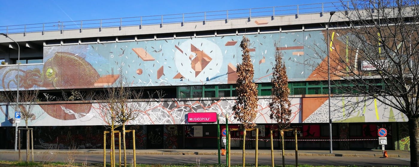 L'edificio di Via Boifava col grande murale e l'insegna magenta di Musicopoli