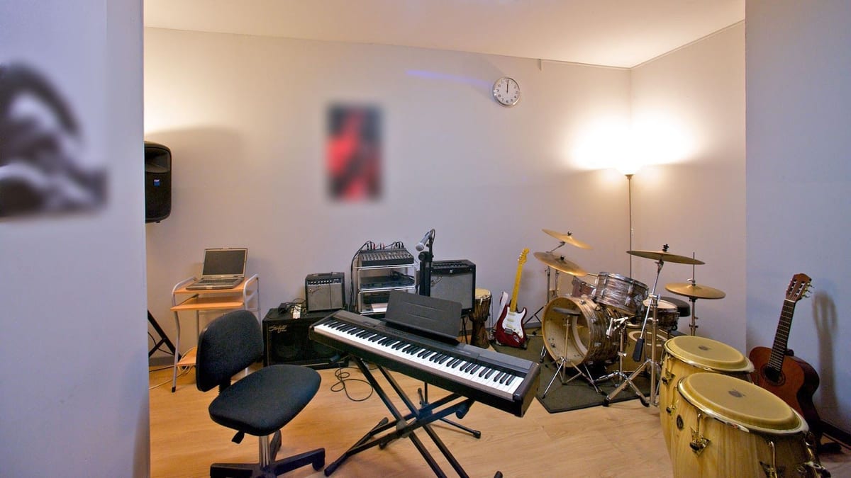 La sala prove: batteria, tastiera, amplificatori e una chitarra elettrica