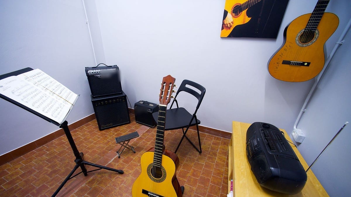 L'aula di chitarra: una chitarra classica, il leggio e due amplificatori