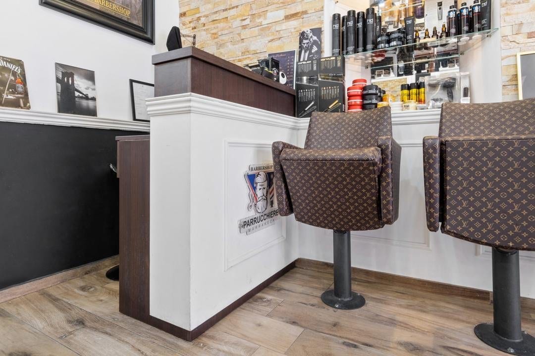 Poltrone in monogramma e bancone con il logo Barbershop Marrakech