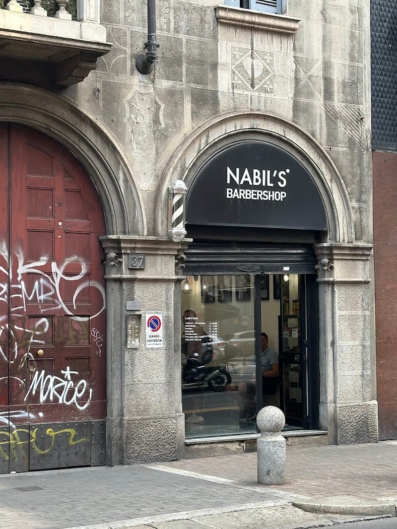 Vetrina Nabil's Barbershop sotto un arco milanese