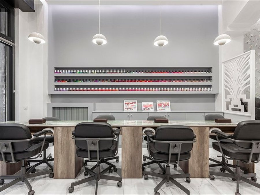 Il tavolo manicure condiviso davanti alla parete degli smalti