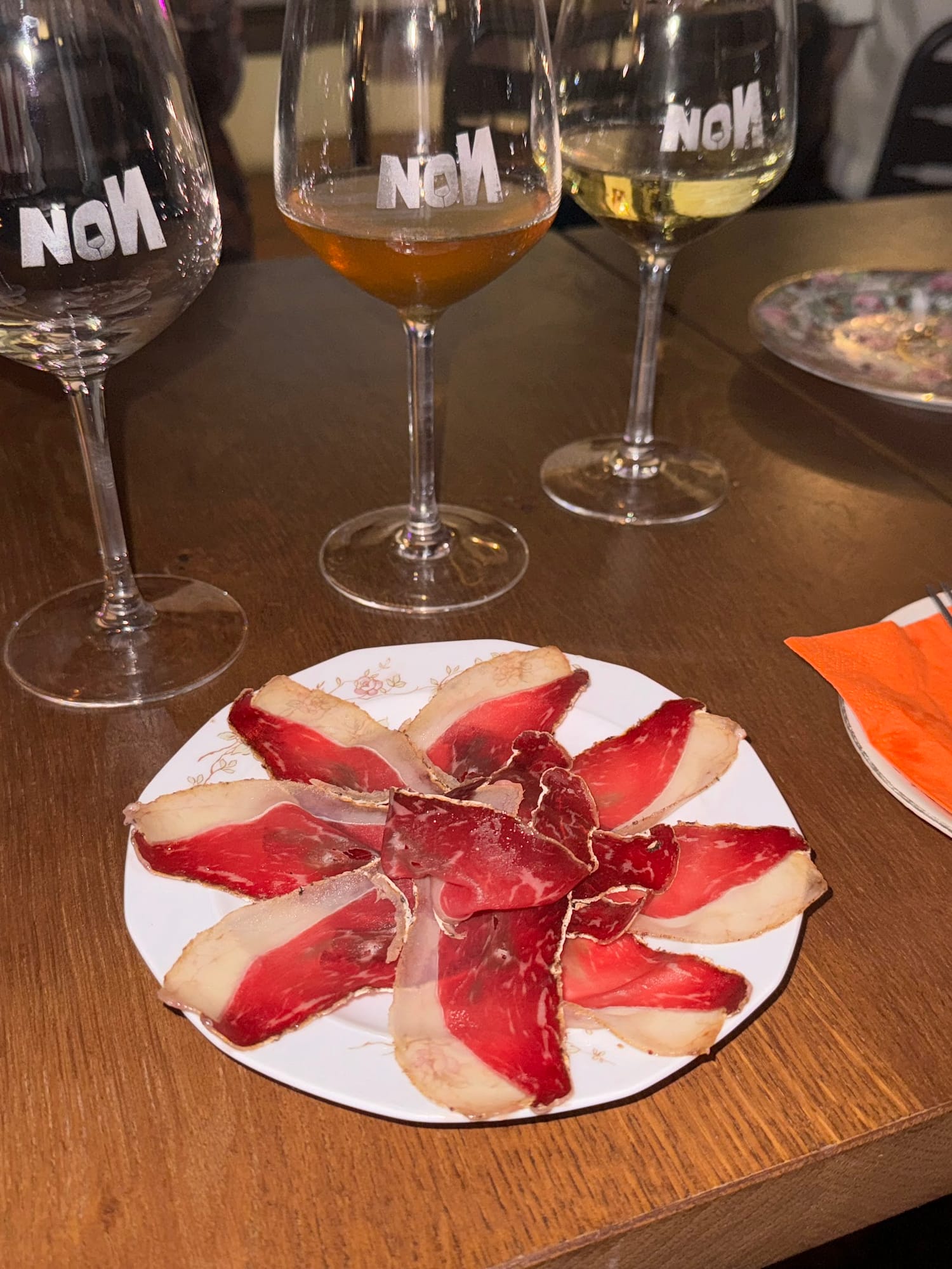 Tre calici marchiati NON con un piatto di salumi