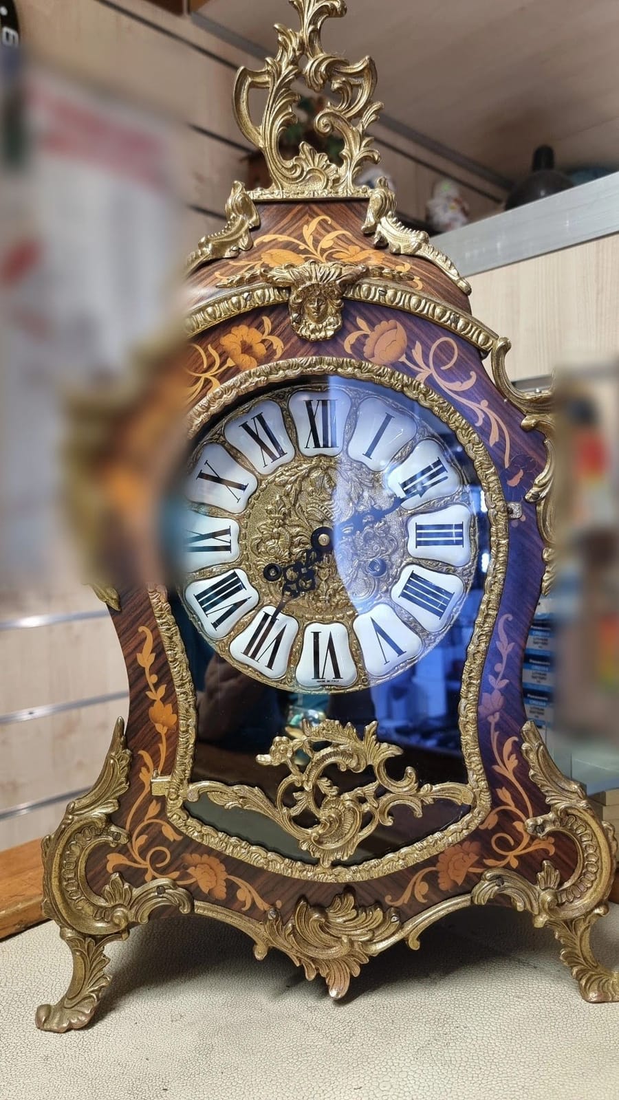 Una pendola intarsiata col bronzo dorato e il quadrante a numeri romani.