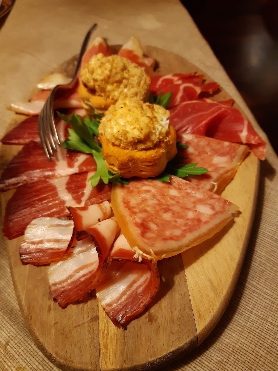 Tagliere di legno con salumi tipici milanesi e due sformatini impanati