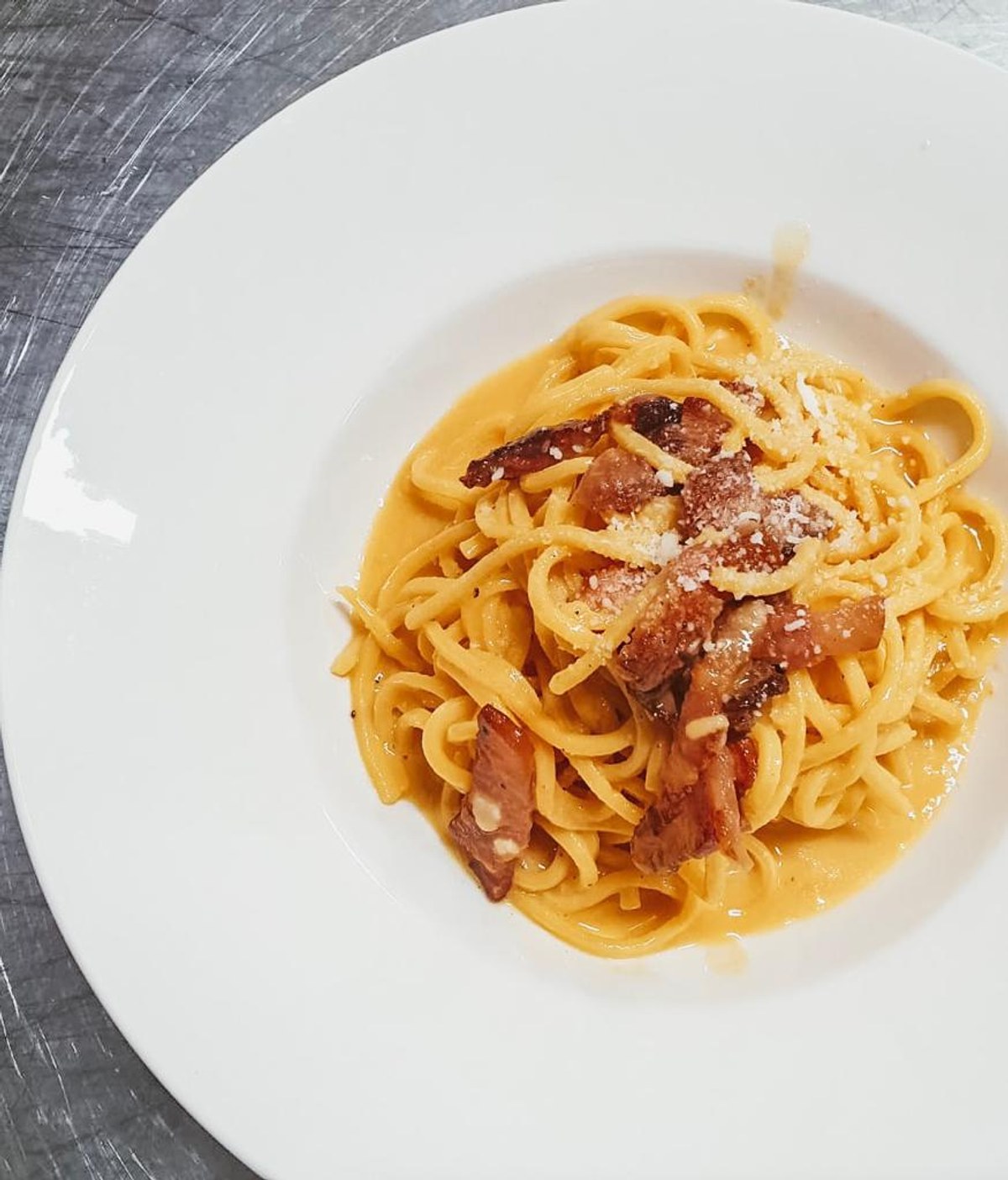 Un piatto di tonnarelli alla carbonara con guanciale e pepe