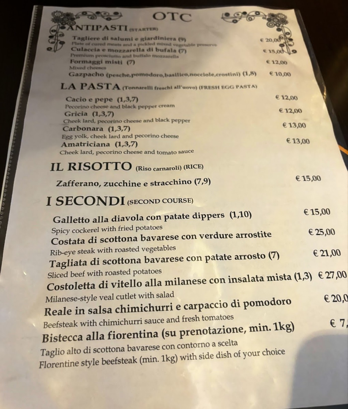 Il menu dell'osteria, intestato OTC, con antipasti, pasta, risotto e secondi in italiano e inglese