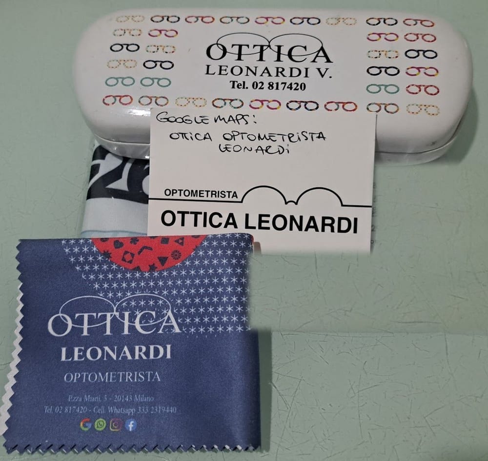 L'astuccio bianco con tanti occhialini colorati, il biglietto col logo e il panno blu con l'indirizzo