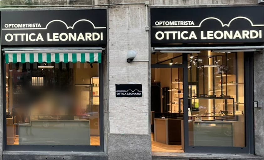 Le due vetrine di Ottica Leonardi in Piazza Miani, con le insegne nere e la linea bianca a due archi