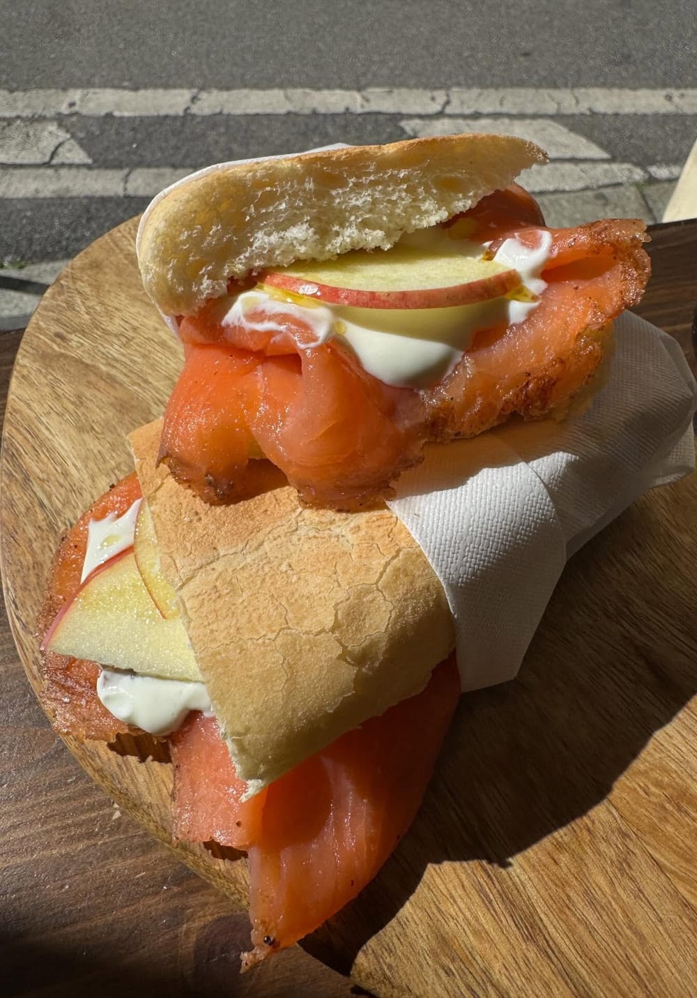 Lo Special Pastrami: il pastrami di salmone, lo yogurt e le fettine di mela nel pane, sul tagliere col tovagliolo.
