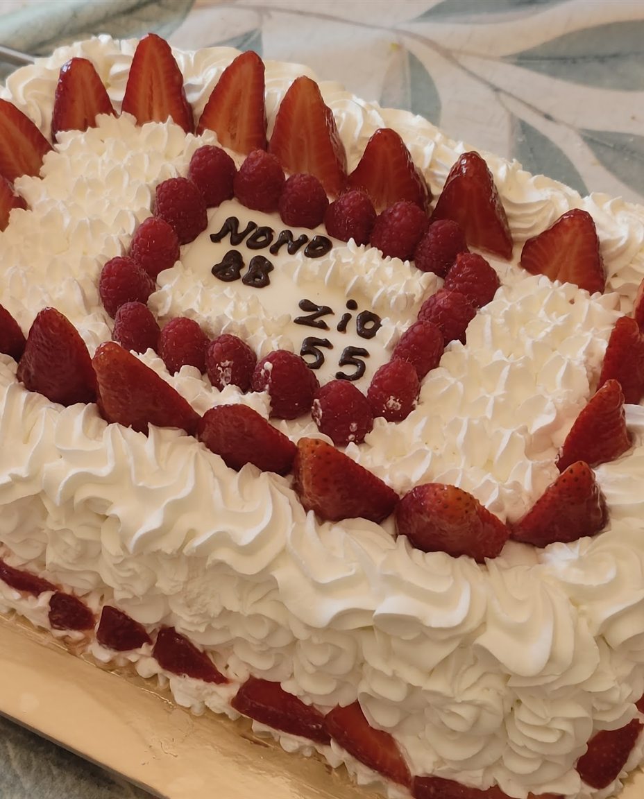 Torta di compleanno con panna montata e fragole fresche