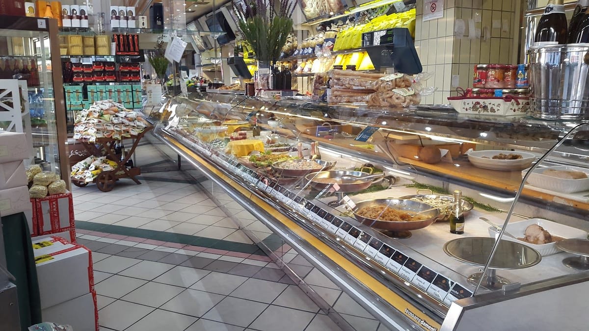 Il lungo banco vetrina del pastificio con le teglie della gastronomia