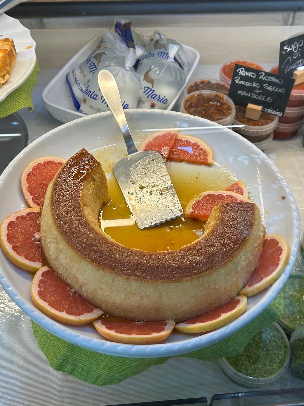 Un budino con le fette di pompelmo, su un piatto bianco