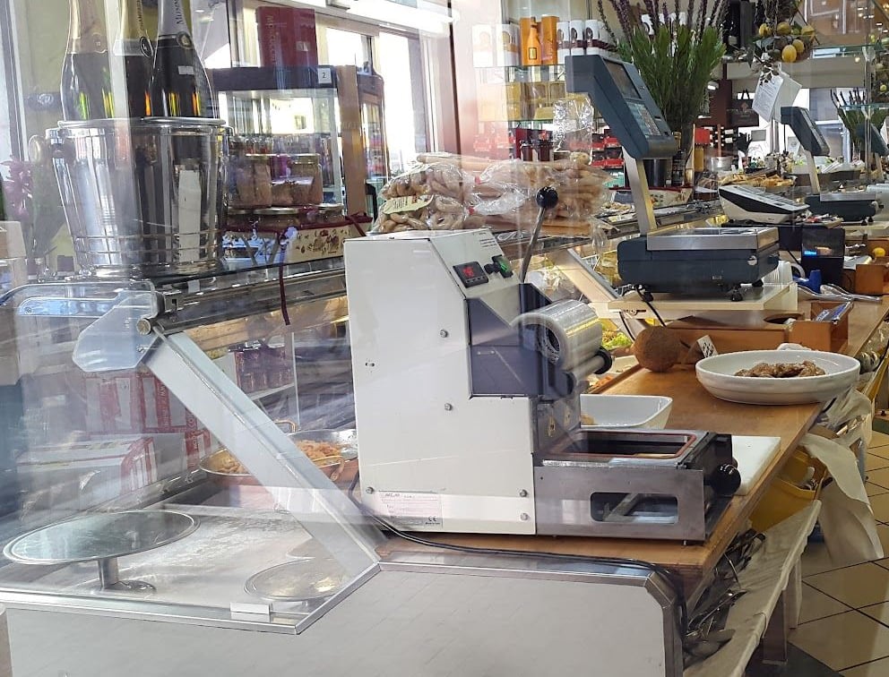 La macchina per la sfoglia con i rulli, sul banco del pastificio, dietro il vetro