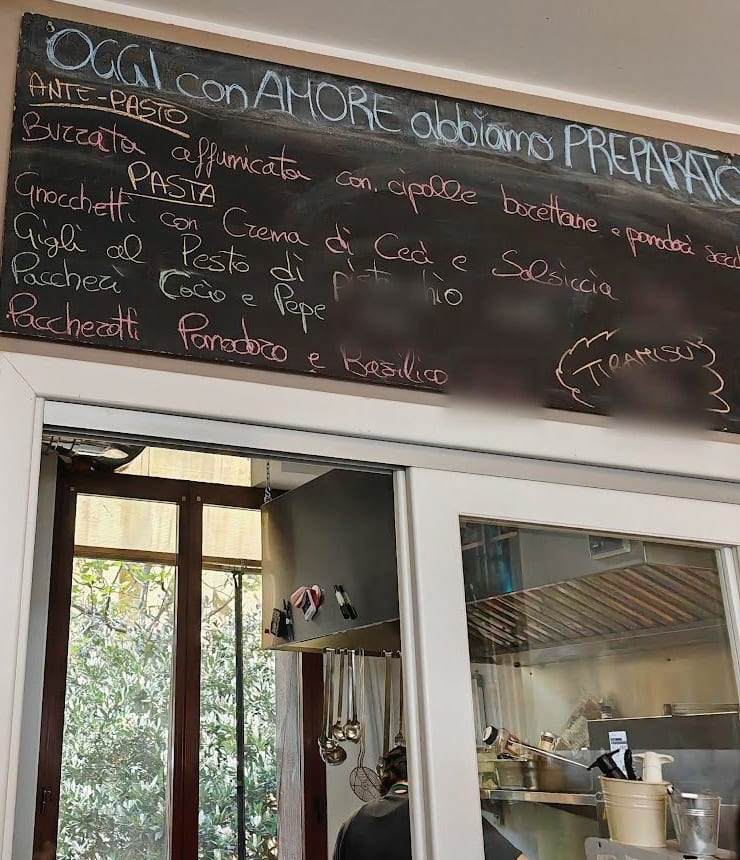 La lavagna «Oggi con amore abbiamo preparato» sopra il passavivande della cucina.