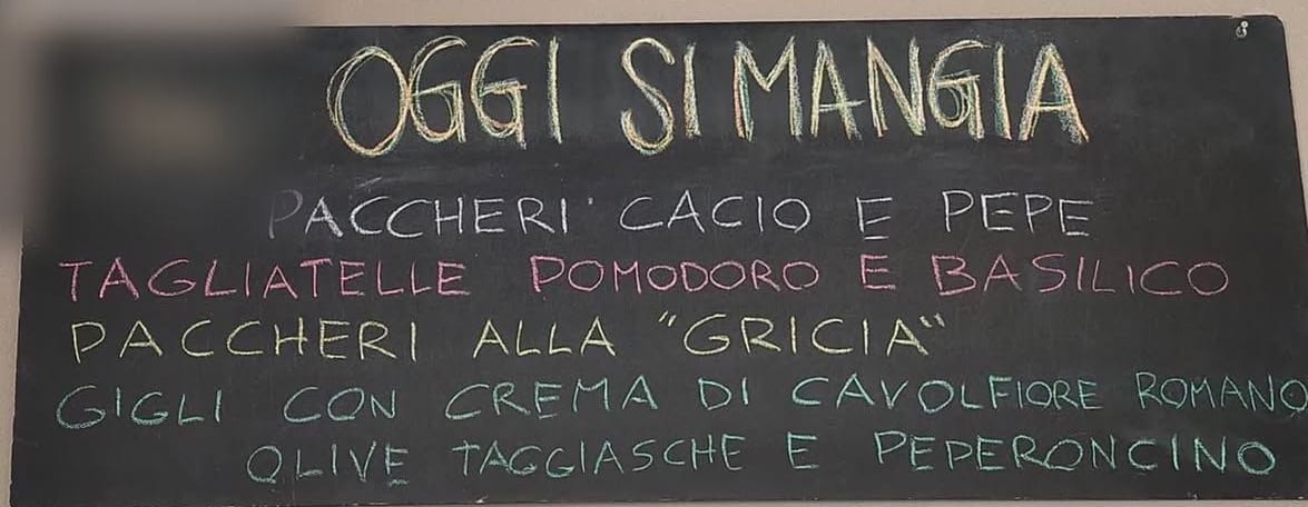 La lavagna «Oggi si mangia»: paccheri cacio e pepe, tagliatelle pomodoro e basilico, paccheri alla gricia, gigli con crema di cavolfiore romano, olive taggiasche e peperoncino.