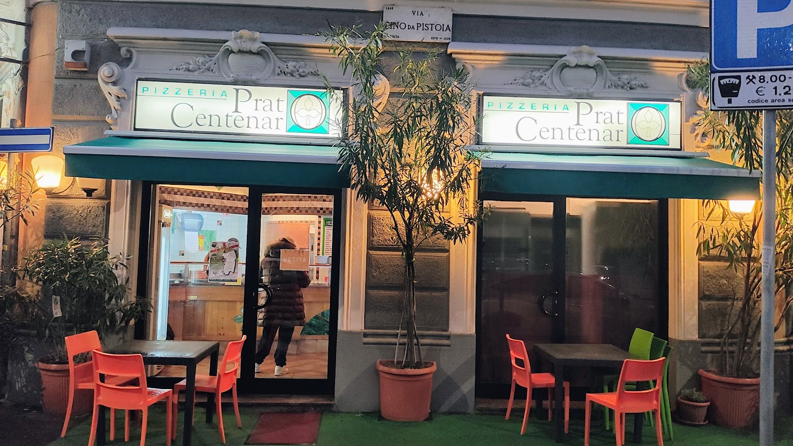 Le insegne di Prat Centenar in Via Cino da Pistoia, con le tende verdi e i tavolini fuori