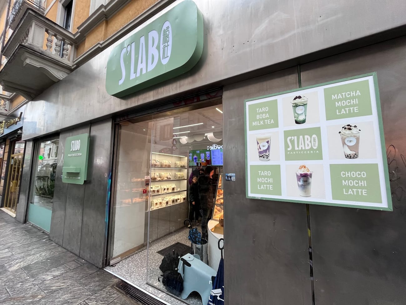 La vetrina di S'Lab con l'insegna verde in Via Paolo Sarpi
