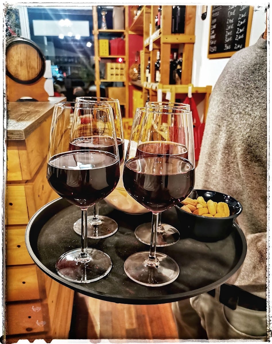 Un vassoio con tre calici di vino rosso e stuzzichini da Semplicemente Vino
