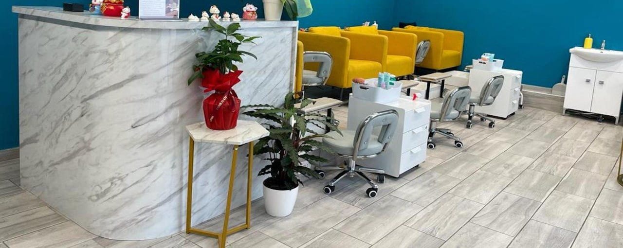 Il bancone di marmo curvo con un'orchidea e le piante; dietro, le poltrone senape.