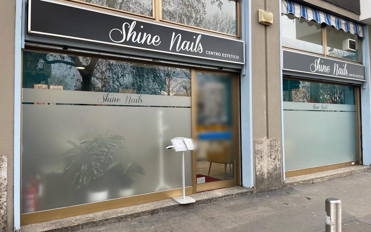 Il salone da fuori: l'insegna nera con la scritta Shine Nails in corsivo bianco, la vetrina satinata col nome.