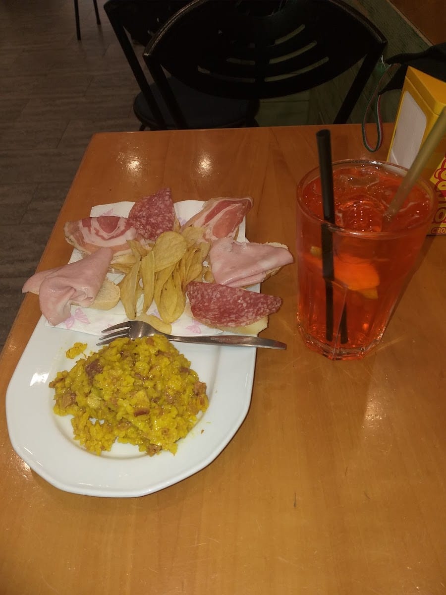Un aperitivo con salumi, patatine e spritz