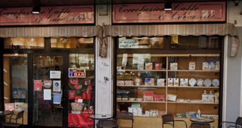 La bottega da fuori: le due insegne «Torrefazione Caffè & Caramelle», le tende a righe, le vetrine e i tavolini sul marciapiede.