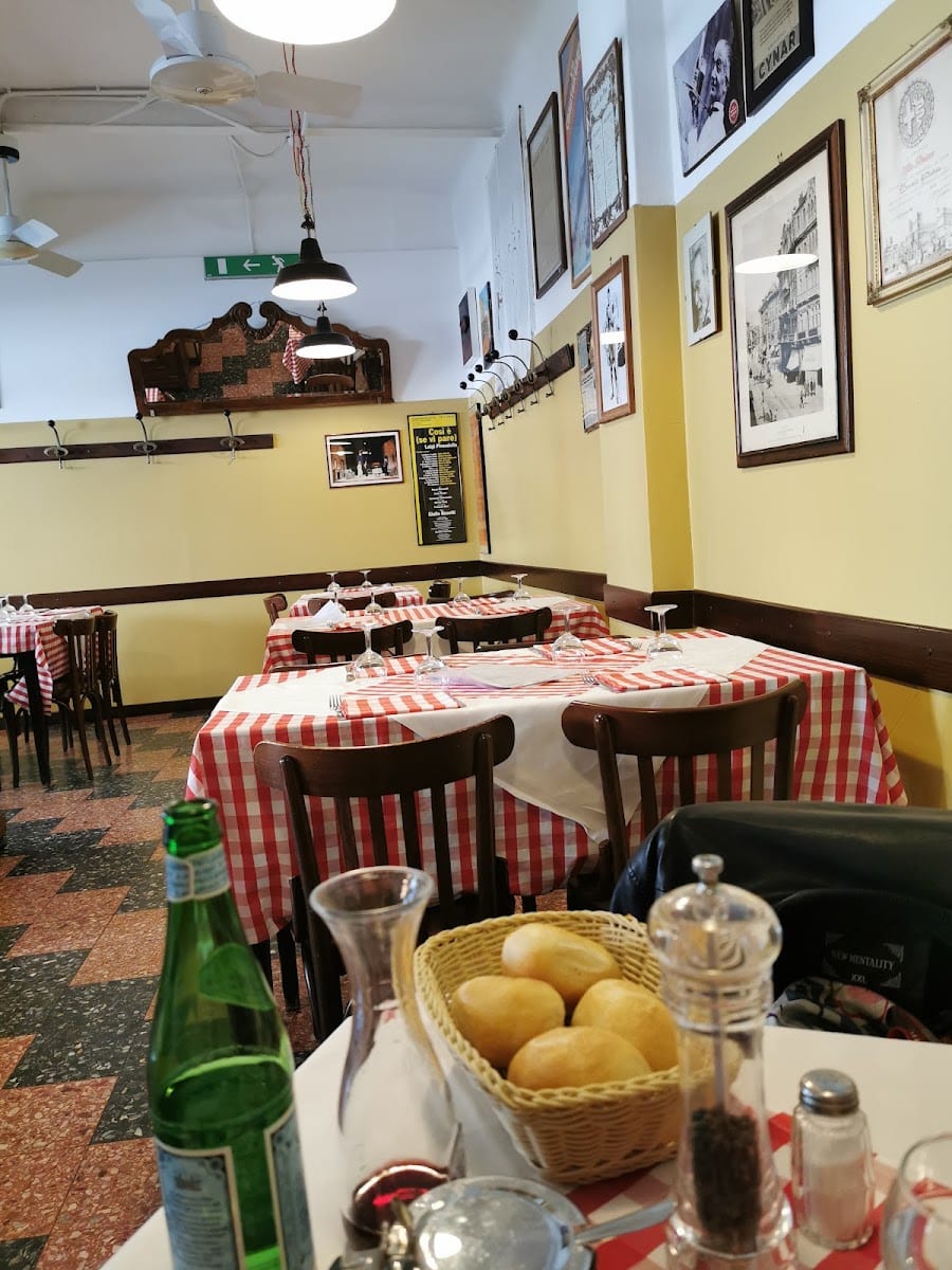 La sala della trattoria con tovaglie a quadretti e foto in bianco e nero alle pareti