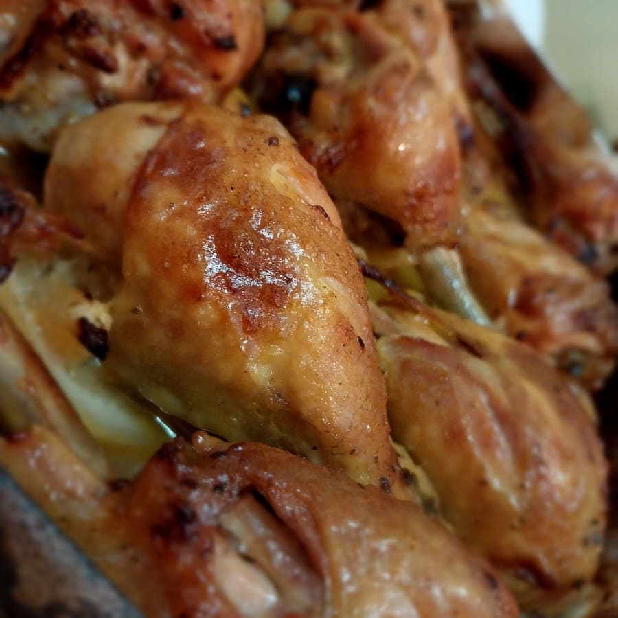 Il pollo a pezzi in teglia, lucido del suo fondo di cottura.