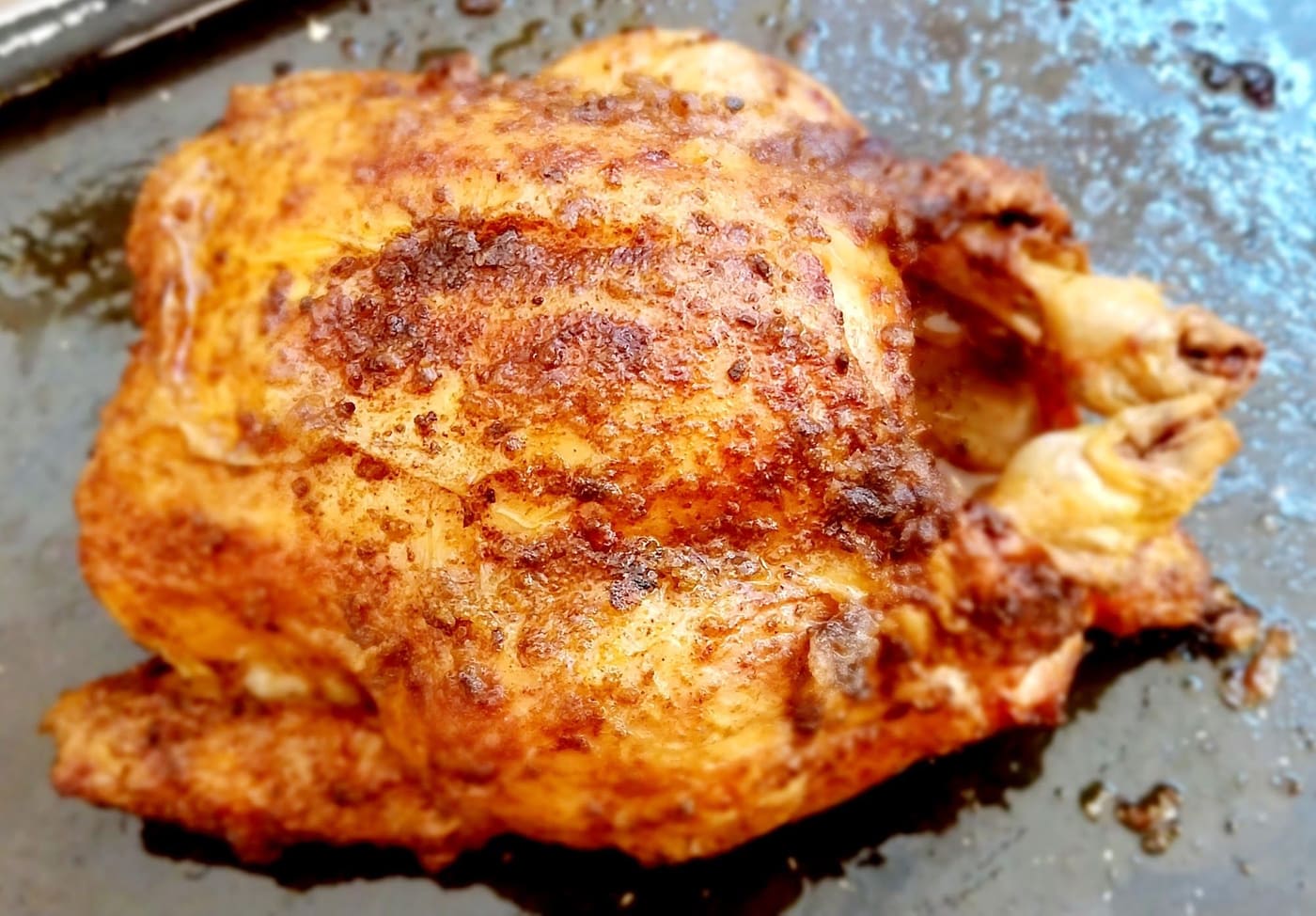 Il pollo intero, dorato, appena uscito dal forno.